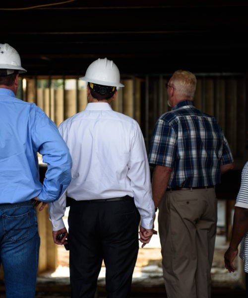 Men with hard hats looking at construction site